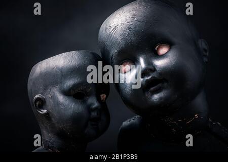Paar gruselige Puppen in der Dunkelheit Stockfoto