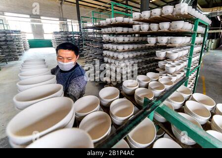 Shijiazhuang, Chinas Provinz Hebei. Februar 2020. Ein Arbeiter arrangiert Keramikprodukte in Handan, der nordchinesischen Provinz Hebei, 26. Februar 2020. Verschiedene Firmen in Hebei haben die Produktion in letzter Zeit wieder aufgenommen. Credit: Wang Xiao/Xinhua/Alamy Live News Stockfoto