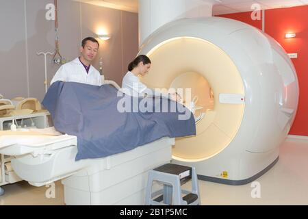 Mrt-Maschine und Bildschirme mit Arzt und Krankenschwester Stockfoto