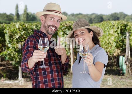 Ein Paar mit Weingläsern gegen Weinberge Stockfoto