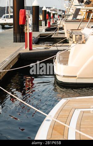 Mehrere Motorbootsterns am Yachthafen mit Seilen Stockfoto