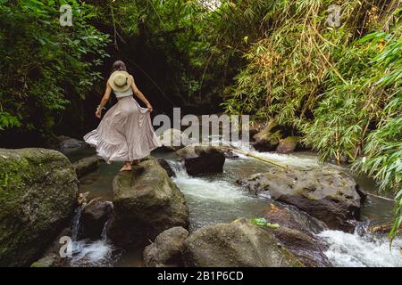 Frau, die auf Felsen des Flussbestands spazieren geht, Foto Stockfoto