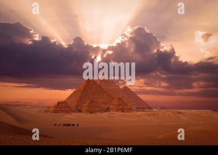 Pyramiden gizeh ägypten bei Sonnenuntergang mit Karavane-Kamelzug im Hintergrund Stockfoto