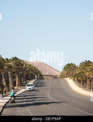 Ein Motorroller, der von einem Gentleman auf der Straße auf Lanzarote gefahren wird, Kanarische Inseln Spanien Stockfoto