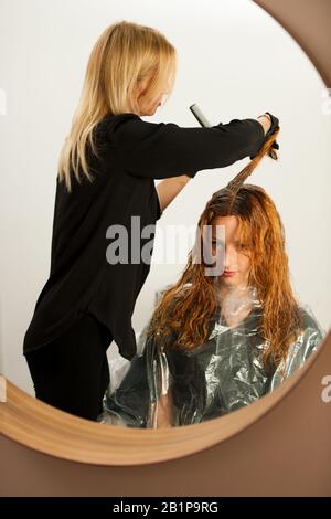 Haarstylisten bei der Arbeit - Friseursalon, der Farbe auf einsames Haar anwendet Stockfoto