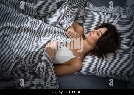 Hübsche, junge Frau im Bett, schnell eingeschlafen. Bedeutung des Schlafkonzepts Stockfoto