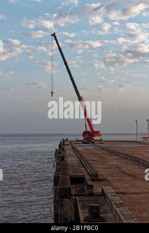 Ein mobiler Panossi-Kranich mit Jib verlängerte sich am Ende eines Piers in der Öffnung des Amazonas bei Dawn. Stockfoto