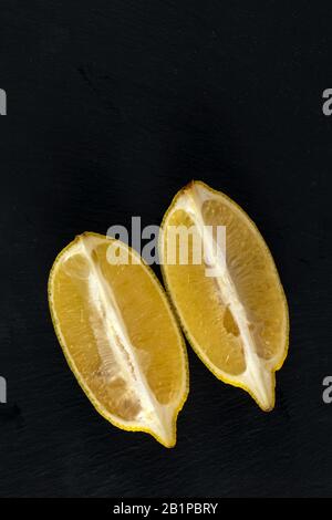 Frische Zitronen auf dunklem Steintisch. Reifer limon von oben. Stockfoto