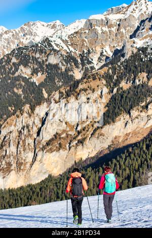 Mädchen Freunden sich während einer Winterwanderung auf dem Schnee in den Bergen an Stockfoto