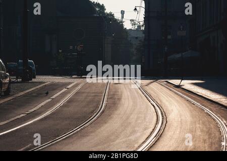 Krakaus alte Straße mit Tramgleisen und Kopfsteinpflaster im Morgenlicht. Dominikanische Straße, Krakow, Polen Stockfoto