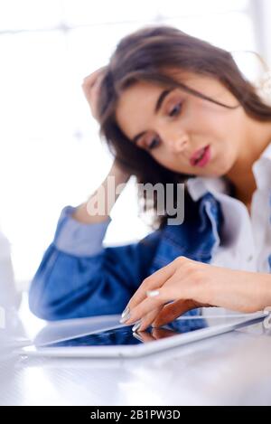 Frau verwendet ein Tablet und sucht nach Informationen im Internet. Stockfoto