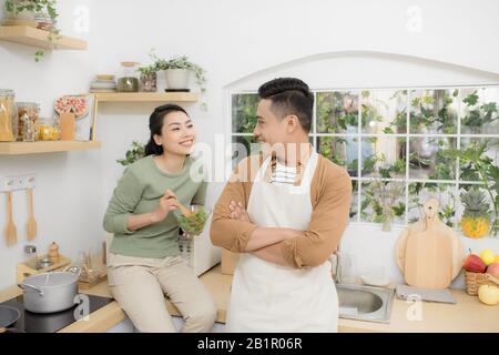 Glückliches junges Paar, das Essen und die Unterhaltung in der Küche Stockfoto