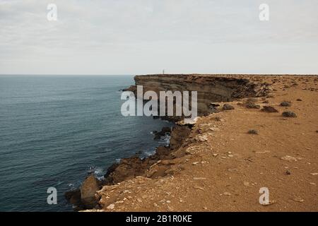 Schöne zerklüftete Küste mit Wellen, die gegen die Klippen krachen Stockfoto
