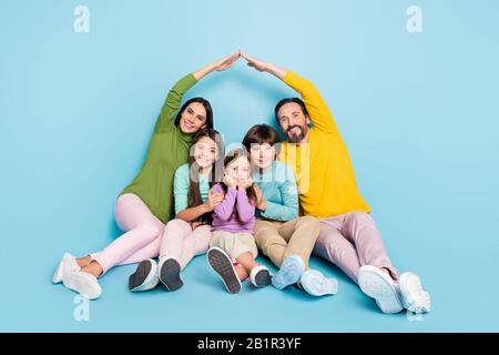 Portrait von nettem attraktiven charmanten charmanten, fröhlichen großen Familiensitzmama Papa machen Dach neue Wohnung Umzug isoliert auf hell Stockfoto