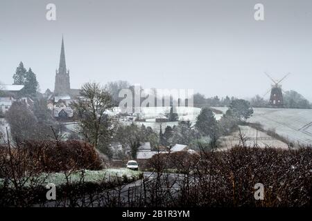 Thaxted, Großbritannien. Februar 2020. Wetter in Großbritannien. Thaxted Essex England bedeckt mit Schnee 27. Februar 2020 Thaxted Church aus dem 14. Jahrhundert und John Webbs Windmaill aus dem Jahr 2007, die durch einen leichten Schneebefall, den ersten in diesem Winter, von Cutlers Green Thaxted in North Essex gesehen wurde, gesehen wurde. Foto Credit: Brian HARRIS/Alamy Live News Stockfoto
