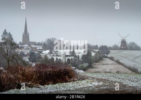 Thaxted, Großbritannien. Februar 2020. Wetter in Großbritannien. Thaxted Essex England bedeckt mit Schnee 27. Februar 2020 Thaxted Church aus dem 14. Jahrhundert und John Webbs Windmaill aus dem Jahr 2007, die durch einen leichten Schneebefall, den ersten in diesem Winter, von Cutlers Green Thaxted in North Essex gesehen wurde, gesehen wurde. Foto Credit: Brian HARRIS/Alamy Live News Stockfoto