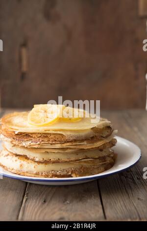 Honig- oder Ahorn-Sirup, der über Crepes gießt. Nahansicht des Stapels dünner Pfannkuchen, blini Stockfoto