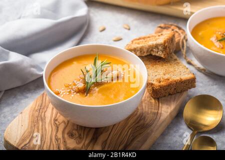 Hausgemachte Herbst-Butternuß-Kürbis-Creme-Suppe mit Brot und Samen. Draufsicht Stockfoto