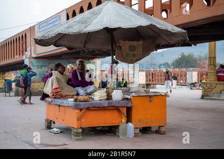 Haridwar, Indien - Februar 22, 2020: Zwei indische Männer, die Reis an einem Messestand in der Nähe der Zeremonie von Aarti Ganga verkaufen Stockfoto