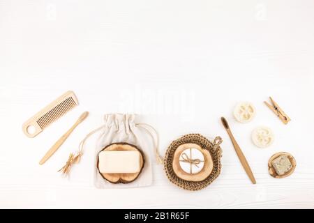 Set mit umweltfreundlichen Badezimmer-Accessoires auf weißem Holzhintergrund. Null-Abfall-Konzept. Kunststofffrei. Flacher Laienstil. Kopierbereich. Stockfoto