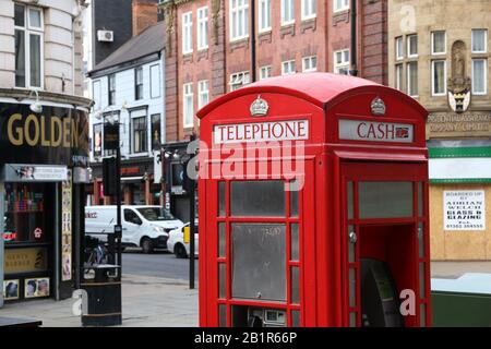 Doncaster, Großbritannien - 12. JULI 2016: Roter Telefonstand mit Geldautomaten in der Innenstadt von Doncaster, Großbritannien. Es ist eine der größten Städte in South Yorkshire mit Einwohnern Stockfoto