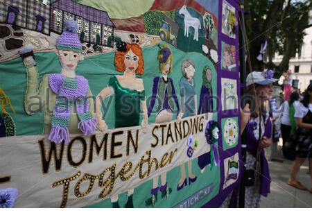 Ein Banner mit den Worten, Die Frauen in Wwestminster zusammenstehen, die von Frauen gemacht wurden, die an der 100-Jahre-Wahlparade teilnahmen. Stockfoto