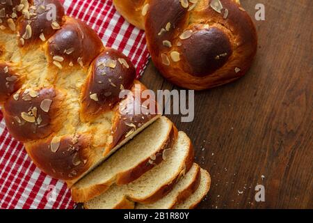 Süßes Brot, ostertsoureki Cozonac auf Holztisch geschnitten, Draufsicht. Geflochtene Brioche, festliche traditionelle Herausforderung Stockfoto