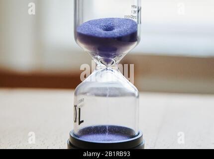 Berlin, Deutschland. Februar 2020. Violetter Sand läuft in einer Sanduhr hinunter. Credit: Annette Riedl / dpa / Alamy Live News Stockfoto