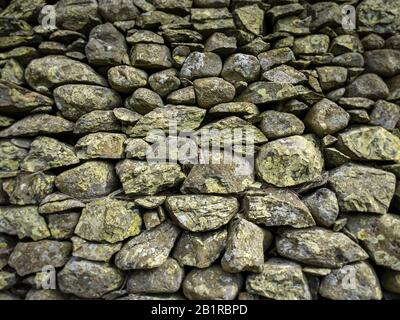 Wandstruktur aus trockenem Stein. Vollformats-Struktur einer traditionellen britischen Trockensteinmauer, wie sie typischerweise im ländlichen Wales und im Norden Englands zu finden ist. Stockfoto