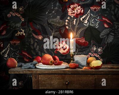 Dunkle Stimmung Stillleben mit Äpfeln auf einem rustikalen Tisch auf farbenfrohem Hintergrund Stockfoto