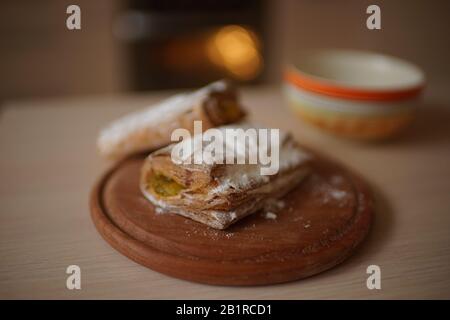Brötchen mit Ananasmarmelade in einer orangefarbenen Platte auf einem Holz. Teetasse und Backofen-Hintergrund. Stockfoto