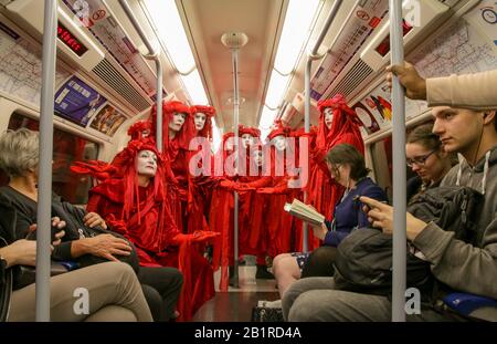 @ptrbrks 'Etikette'. Die Rote Rebel-Brigade ist ein Aufführungs-Protest, der Emotionen hervorruft, um den Alltag zu unterbrechen und zu Klima-Aktionen aufzufordern. Stockfoto