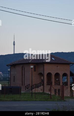 Kirche in den Vorstädten Belgrads. Im Hintergrund steht der Turm auf Avala Stockfoto