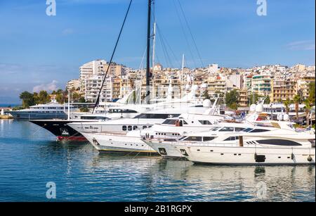 Yachts angedockt im Seehafen in Piräus, Athen, Griechenland. Moderne Motorboote, die im Sommer in einem wunderschönen Yachthafen anlegen. Schöner Blick auf weiße Jachten im Hafen. Stockfoto