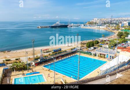 Athen - 7. Mai 2018: Strand in Piräus, Griechenland. Schöner Blick auf die schöne Küste. Blick auf die Stadt am Meer mit Schwimmbädern und angedocktem y Stockfoto