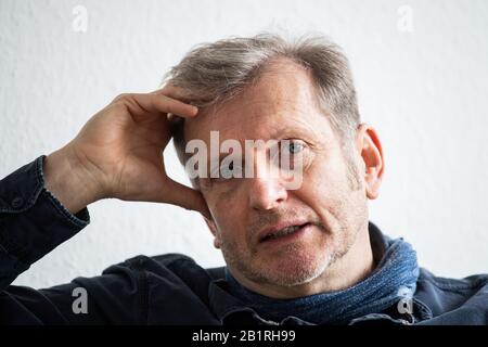 Mainz, Deutschland. Februar 2020. Gerhard Trabert, Sozialmediziner, sitzt während der Redaktionssitzung mit der Deutschen Presse-Agentur auf dem grünen Sofa. Kredit: Andreas Arnold / dpa / Alamy Live News Stockfoto