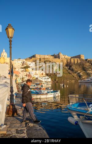 Procida, ITALIEN - 3. JANUAR 2020 - Blick auf die Corricella-Bucht im Sonnenuntergang, einem romantischen Fischerdorf in Procida, Italien Stockfoto