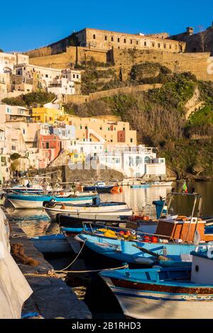 Procida, ITALIEN - 3. JANUAR 2020 - Blick auf die Corricella-Bucht im Sonnenuntergang, einem romantischen Fischerdorf in Procida, Italien Stockfoto