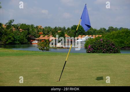 Batam Indonesia - Blick auf ein Golfplatinen-Loch und den Nongsa Point Ferry Terminal im Hintergrund Stockfoto