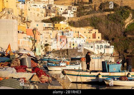 Procida, ITALIEN - 3. JANUAR 2020 - Blick auf die Corricella-Bucht im Sonnenuntergang, einem romantischen Fischerdorf in Procida, Italien Stockfoto