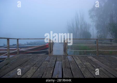 Holzsteg mit Nebel im Hafen von Catarroja Valencia Spanien. Stockfoto