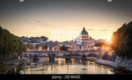 ROM bei Sonnenuntergang Italien. Brücke von Sant'Angelo und Petersdom. Wahrzeichen Roms. Der Petersdom (San Pietro) ist eine der wichtigsten Reiseattraktionen Stockfoto