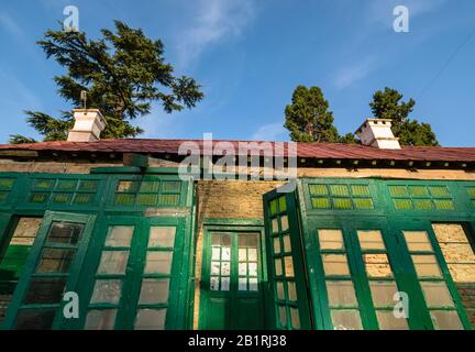 Kausani, Uttarakhand/Indien - 2. April 2019: Die hellgrünen Fenster des Anasakti Ashrams in der Himalaya-Stadt, in der Mahatma Gandhi wohnte. Stockfoto