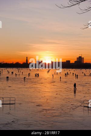 Gefrorene Außenalster, Sonnenuntergang, Alstereisvergnügen, Menschen, Vergnügen, Eis, Schnee, Winter, Hansestadt Hamburg, Deutschland, Stockfoto