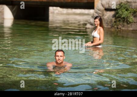 Aktives junges Paar spielt an einem heißen Sommermorgen im Flachwasser Stockfoto