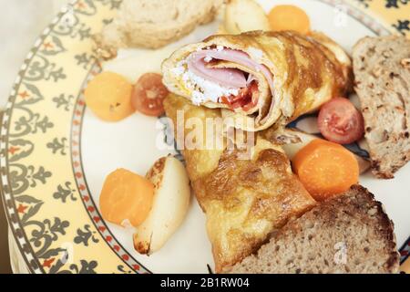 Hausgemachtes Omelett mit frischen Kirschtomaten, Käse und Kartoffeln Stockfoto