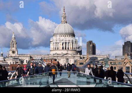 Der Blick entlang der Millennium Bridge London zur Kuppel der St Pauls Cathedral mit einem interessanten Himmel von blauem Himmel und Wolken mit Menschen auf der Brücke