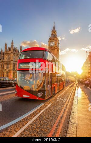 Big Ben mit rotem Bus gegen farbenfrohen Sonnenuntergang in London, England, Großbritannien Stockfoto