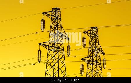 Lectric Power Industry. Sendetürme oder Elektrizitätspylone mit goldenem Himmelshintergrund Stockfoto