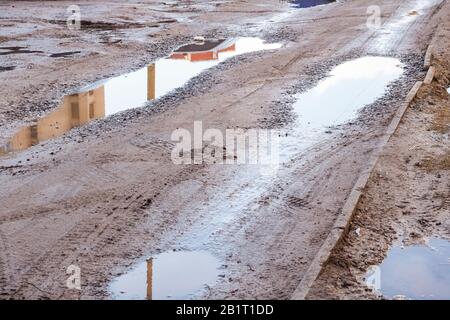 Pfütze und Schlamm auf einer sandigen Straße Stockfoto